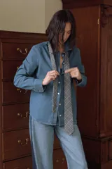 Jeans de tiro medio y corte barrel, confeccionados en denim de lavado celeste claro, con paneles laterales de denim azul oscuro a contraste. Presentan cinco bolsillos y cierre frontal con cremallera y botón.