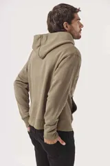 Buzo hoodie color arena con capucha, bolsillo tipo canguro y pequeño estampado en el pecho.