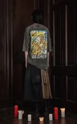 Remera gris de manga corta con cuello redondo y calce oversize. Estampa frontal con el diseño de la carta del tarot 'El Loco'.