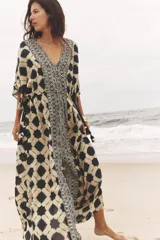 Vestido amplio estilo caftán con estampado geométrico en tonos beige y azul, escote en pico con lentejuelas y manga ancha por debajo del codo. Cintura ajustable con cordones con borlas.