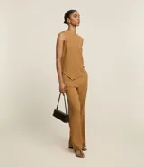 Pantalón recto color ocre con textura acanalada, de cintura alta con elástico y bolsillos laterales.