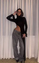 Top negro de cuello alto y mangas largas con abertura lateral y detalle cut-out en el abdomen.