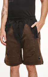 Bermuda negra de algodón rústico con calce oversize, elástico en la cintura y bolsillos con cierre.