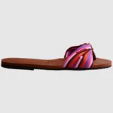 Sandalias Havaianas You St Tropez con base marrón y tira de tela estampada con rayas de colores y nudo decorativo.