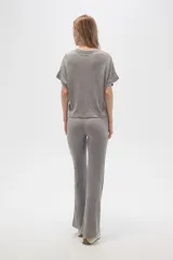 Pantalón gris de poliéster y lurex, holgado y de tiro alto, con textura acanalada.