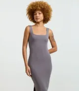 Vestido midi gris de punto, con breteles anchos y escote cuadrado. Presenta una abertura lateral en la falda.