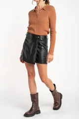 Cardigan negro de tejido de punto acanalado, con cuello polo, corte al cuerpo y cierre frontal con botones.
