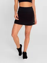 Falda deportiva negra con calza interior, de secado rápido. Diseño acampanado con plisado en la parte trasera, pretina ancha con bolsillo con cierre y bolsillo interior en la calza.