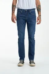 Jean azul de corte slim, con diseño clásico de cinco bolsillos y costuras contrastantes.