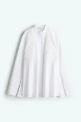 Camisa blanca de algodón con cuello mao, bordado floral tono sobre tono y cierre de botones. Tiene corte holgado, hombros caídos, mangas largas con abertura en los puños y bajo recto.