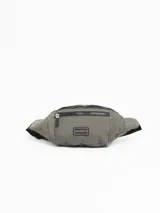 Riñonera color verde militar con correa ajustable negra y cierre superior con cremallera.