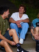 Remera polo negra de corte regular, con cuello y mangas con rayas en contraste blancas y logo bordado en el pecho.