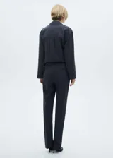 Pantalón de vestir negro con finas rayas verticales blancas, de tiro alto y corte recto.