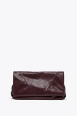 Bolso bandolera tipo sobre color borgoña, con asa fina y cierre imantado con solapa. Incluye bolsillo interior con cierre de cremallera metálica.