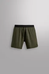 Shorts deportivos color verde oliva confeccionados en tejido técnico ligero y elástico. Cuenta con forro interior, cintura elástica ajustable con cordón, bolsillos laterales, bolsillo de seguridad en espalda con cierre de cremallera, bajo con aberturas laterales y logo estampado en la pierna.