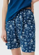 Conjunto de pijama azul con estampado de flores blancas, compuesto por musculosa con bolsillo en el pecho y short con cintura elástica.