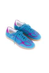 Championes de cuero vacuno color celeste con detalles en fucsia, suela color caramelo y cordones celestes.