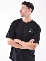 Remera blanca de corte oversized con logo pequeño estampado en el pecho.
