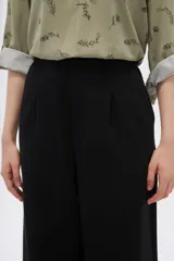 Pantalón negro de corte ancho y tiro alto, confeccionado en viscosa.