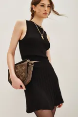 Minifalda negra tejida con cintura ancha elastizada y diseño plisado que genera movimiento.