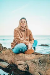 Buzo beige de corte clásico con cuello alto y cierre parcial con cremallera.