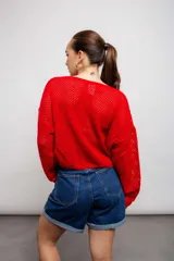 Buzo negro de acrílico con tejido calado y mangas largas.