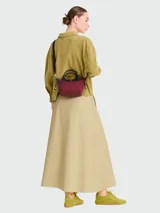 Bolso pequeño tipo tote o bandolera Longchamp modelo Le Pliage Energy XS, color borgoña (vino tinto), con asas cortas negras y correa larga ajustable negra.