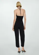 Mono largo negro de tejido fluido con anilla metálica en el cuello halter, tirantes finos y diseño recto.