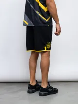 Short deportivo negro con ribete amarillo en el ruedo.