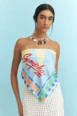 Pañuelo cuadrado de poliéster color rojo con diseño de sol celeste y blanco. Tiene borde con texto "Charrúa Uruguay Since 2015" y estrellas.