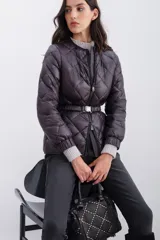 Campera de nylon color berenjena con relleno de pluma, corte regular, cierre doble en delantero y bolsillos. Cinturón elástico gofrado en la espalda y mangas largas con elástico en puños.
