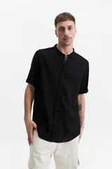 Camisa blanca de manga corta con cuello mao y doblez en las mangas.