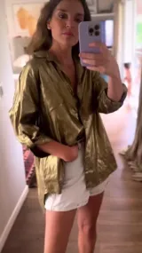 Camisa dorada metalizada de lino, corte holgado, con tajos laterales y espalda más larga.