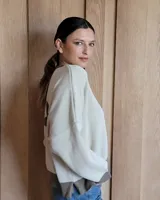 Buzo tostado de corte holgado con cuello redondo y manga larga. Presenta una estrella blanca estampada en la espalda y ribete marrón en cuello y ruedo.