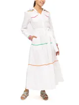 Vestido camisero largo de lino blanco con cuello camisero, cierre frontal con botones y cinturón de lazo. Presenta detalles de bordado ondulado en verde, naranja y rosa en cuello, bolsillos, puños y ruedo.