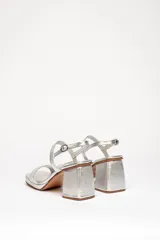 Sandalias plateadas de cuero vacuno con dos tiras horizontales y pulsera con hebilla. Tacón cuadrado de 8 cm y plataforma de 2 cm.