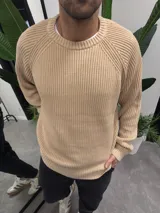 Sweater de hilo color beige, con cuello redondo y mangas largas.