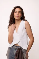 Chaleco marrón con escote en V y cierre cruzado con dos botones.