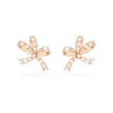 Caravanas de botón con forma de lazo, bañadas en tono oro rosa y engastadas con cristales transparentes.