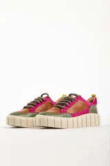 Zapatillas deportivas de cuero color beige con detalles en lila y amarillo.