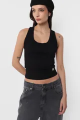 Musculosa blanca de algodón con lycra, corte ajustado y detalle de plastisol transparente en el ruedo.