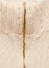 Jersey color crema de punto de canalé con cuello alto y cierre de cremallera frontal.