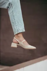 Zapatos estilo Mary Jane color beige, confeccionados en cuero, con taco cuadrado de 6 cm y tira con hebilla sobre el empeine.