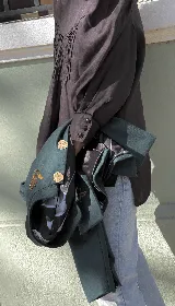 Chaqueta corta azul marino de terciopelo con cuello mao, botones dorados y bordado floral en el frente.