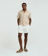 Bermuda de algodón blanca con textura cuadriculada, cintura elástica con cordón ajustable y bolsillos laterales.