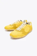Zapatillas deportivas amarillas con detalles en gamuza y malla, cordones blancos y suela color caramelo.