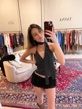 Top halter negro con lunares blancos, de tela tipo gasa, para atar al cuello y con espalda descubierta. Incluye corbatín.