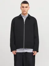 Campera tipo sobrecamisa negra con cierre de cremallera, cuello clásico, mangas largas con puños abotonados y bolsillos frontales. Confeccionada en tejido plano de poliéster reciclado.