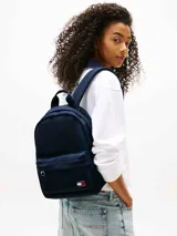 Mochila Tommy Jeans Essential color azul marino, con bolsillo frontal con cierre y logo de la marca. Tiene asa de mano y correas acolchadas ajustables.