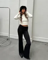 Pantalón alicarado negro de tiro bajo y corte acampanado.